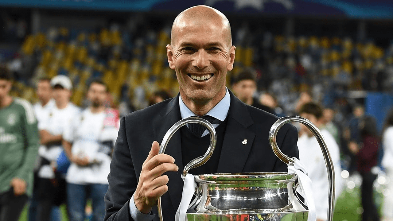 Zinedine Zidane smiling during a press conference, poised for a return to management with France after 2026 World Cup.