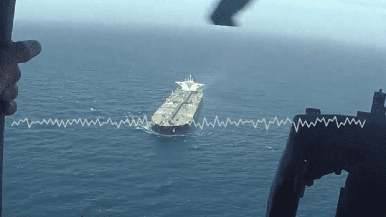US Navy warship intercepting cargo vessel near Strait of Hormuz during Iran blockade