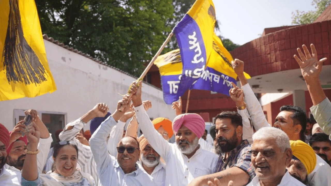 AAP supporters celebrating Punjab civic poll victory with party flags and leaders after municipal election results announcement.
